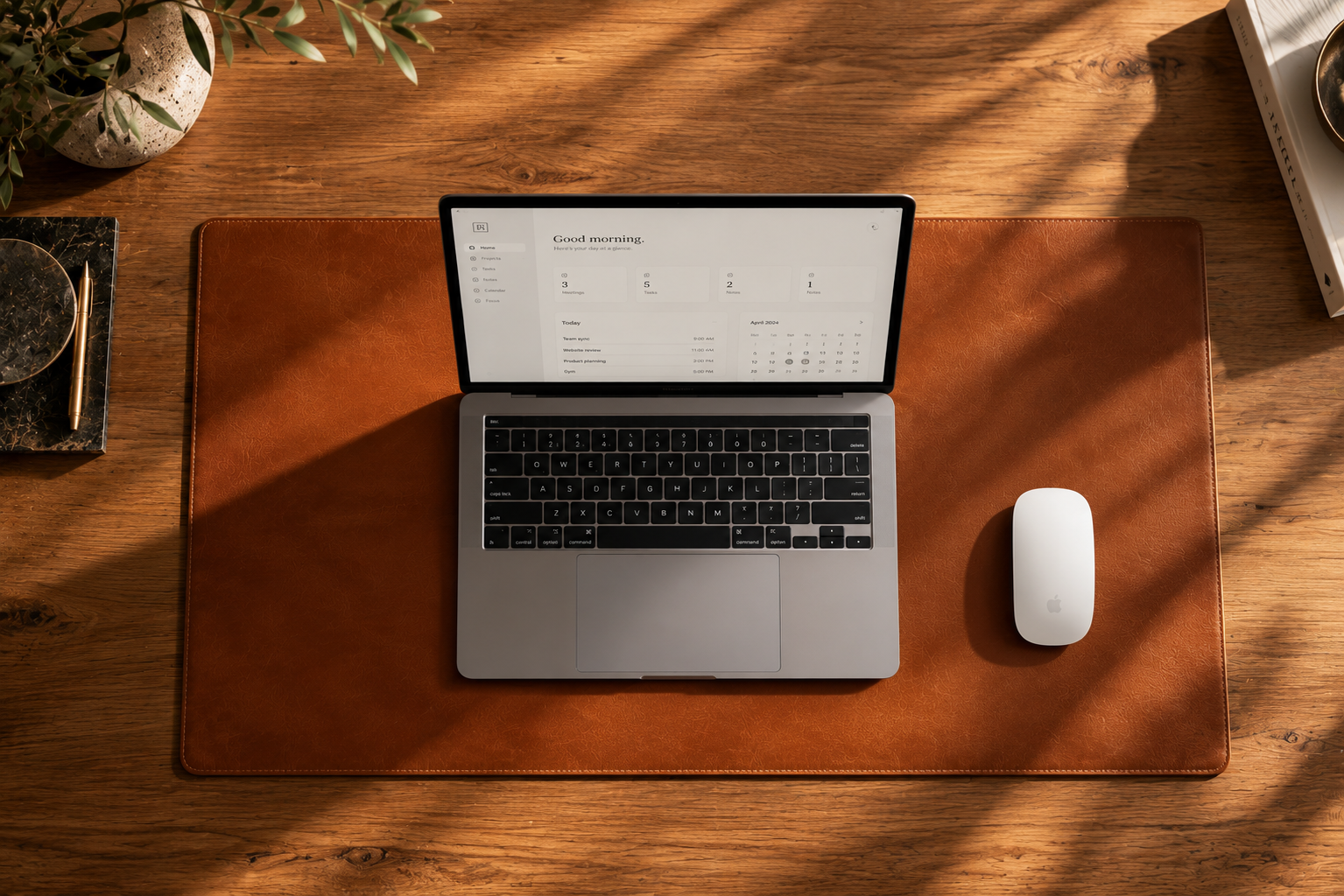Cognac leather desk mat with a laptop and white mouse on a sunlit wooden desk